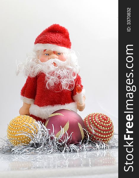 Santa claus toy on white background with Christmas tree decorations.