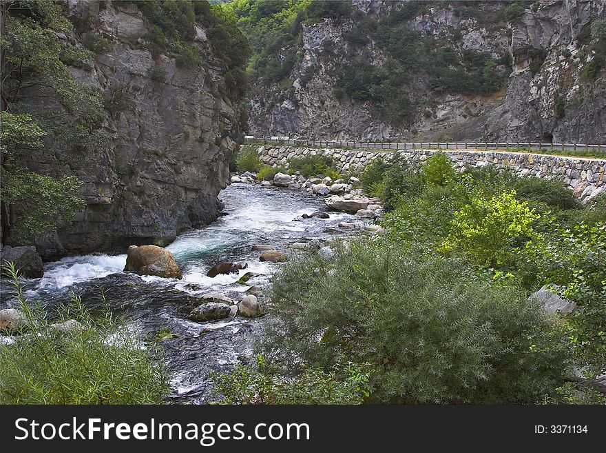 The mountain river in the French Alpes and high-mountainous road. The mountain river in the French Alpes and high-mountainous road