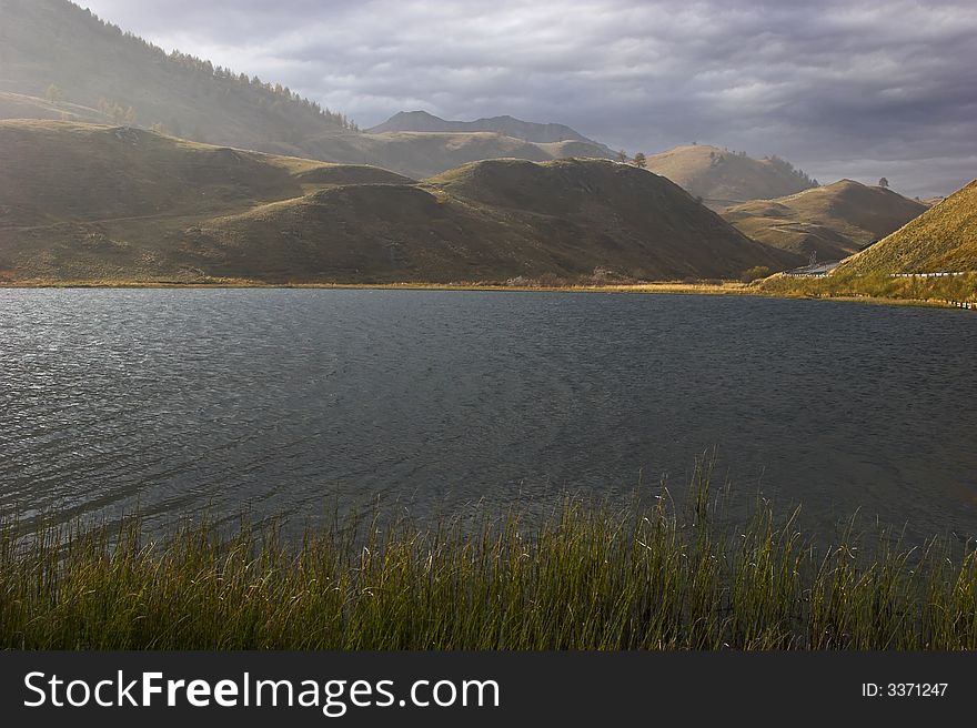 Mountain lake in the Swiss Alpes in cloudy autumn day. . Mountain lake in the Swiss Alpes in cloudy autumn day