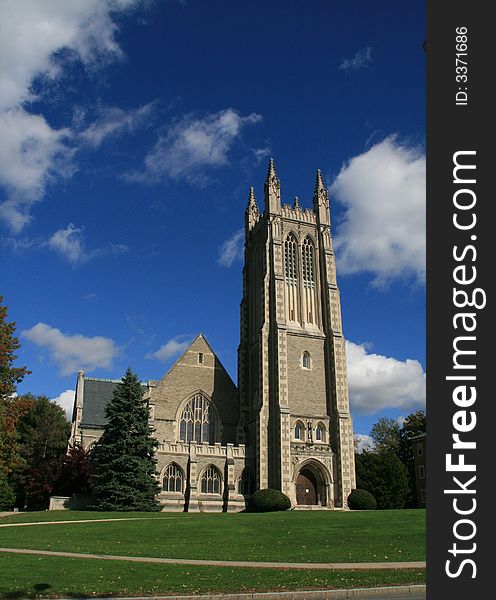 Gothic Cathedral in fall with grassy lawn blue sky and clouds