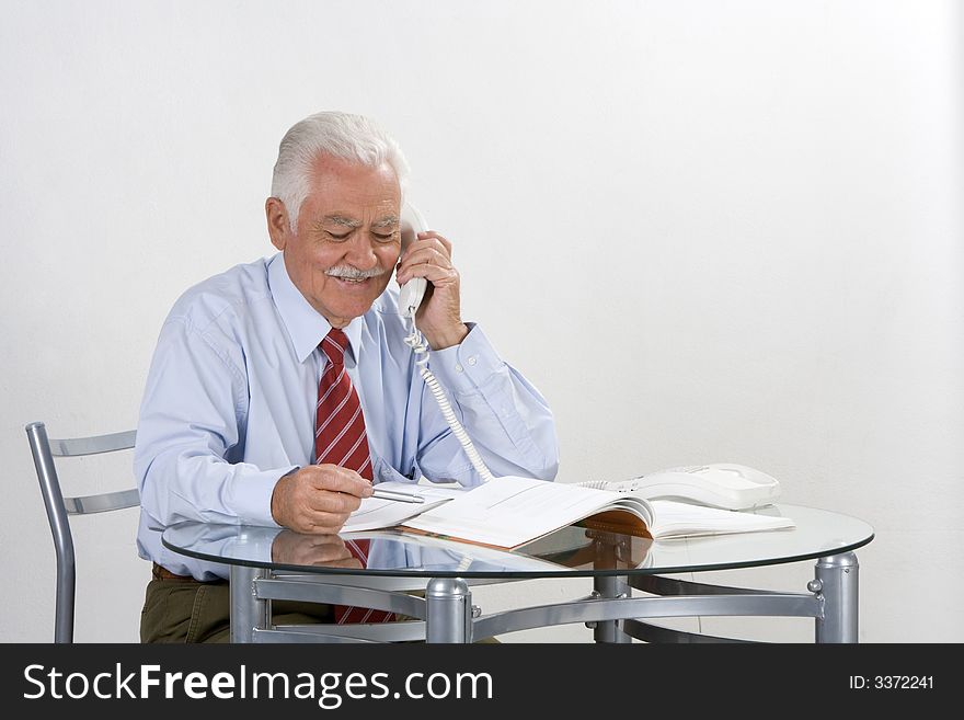 Businessman talking by phone in his 70. Businessman talking by phone in his 70