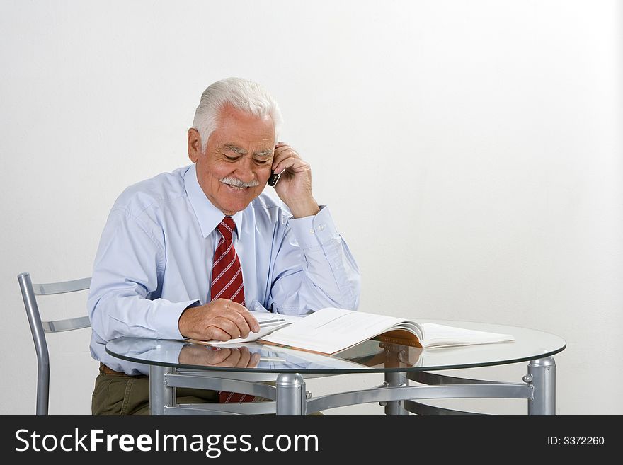 Businessman talking by phone in his 70. Businessman talking by phone in his 70