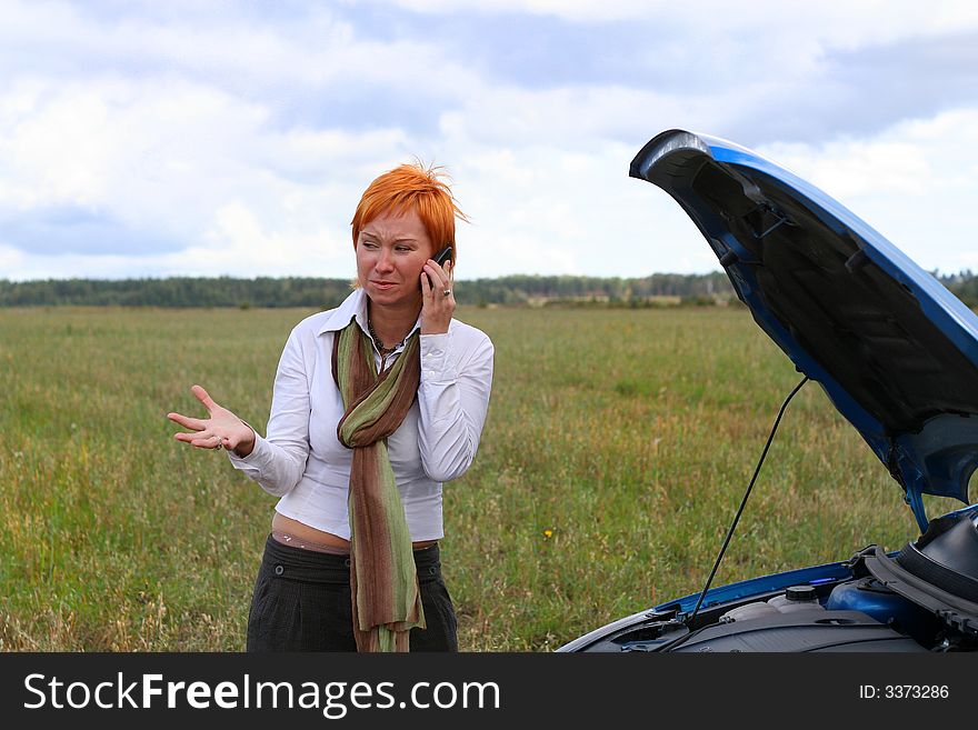 Young red-haired woman with her broken car. The girl have a big problem. Young red-haired woman with her broken car. The girl have a big problem