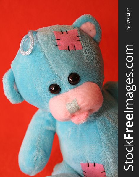 Blue teddy bear against dark orange background. Blue teddy bear against dark orange background