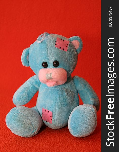 Blue teddy bear against dark orange background. Blue teddy bear against dark orange background