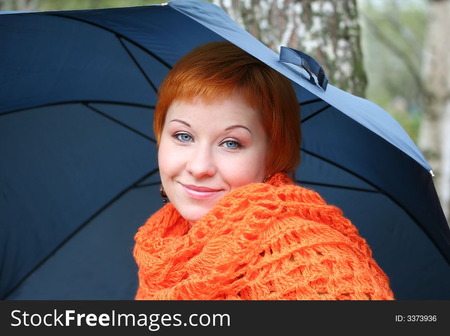 Young red-haired woman in red scarf with umbrella. Young red-haired woman in red scarf with umbrella