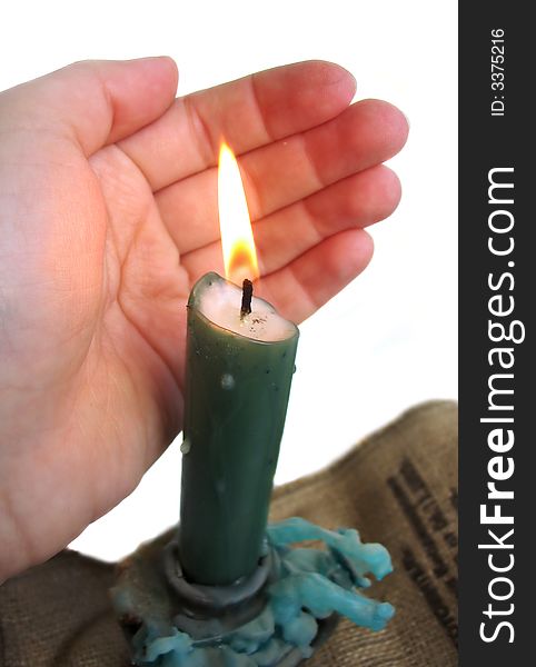 Woman's hand holding a candle on white background