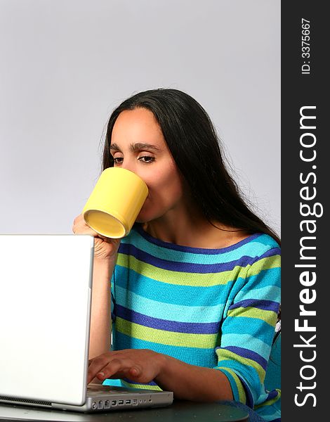 Digital photo of a woman surfing in the internet and drinking a cup of coffee. Digital photo of a woman surfing in the internet and drinking a cup of coffee.