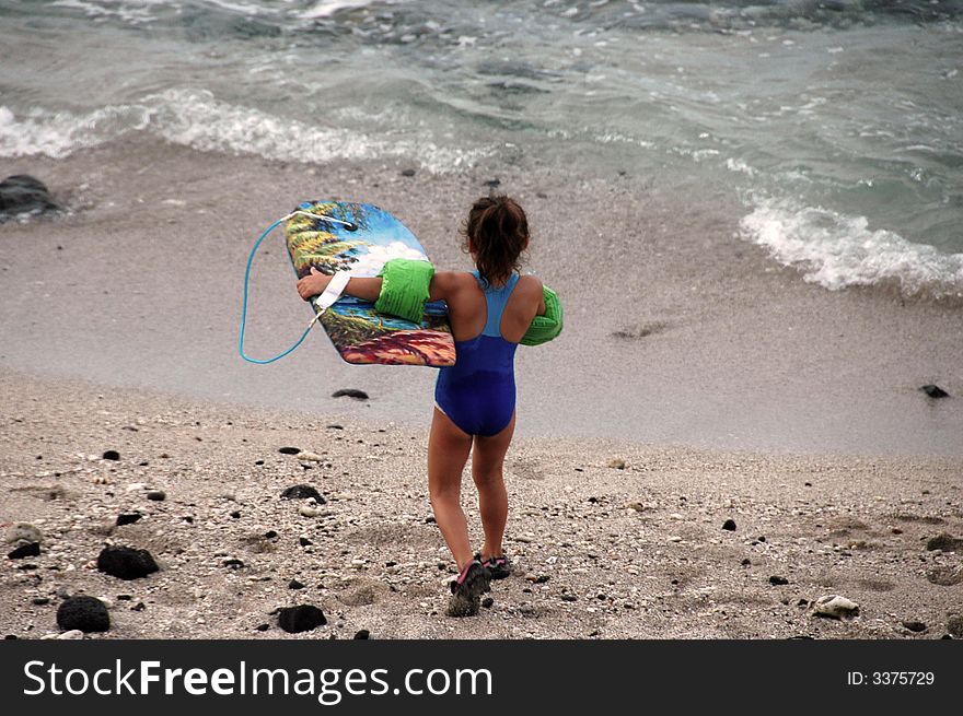 A young girl going swimming on a tropical beach