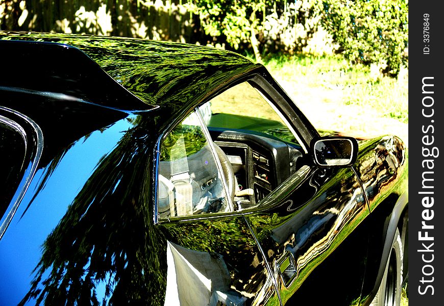 A shot of a black car with the reflections causing a abstract kinda of pattern. A shot of a black car with the reflections causing a abstract kinda of pattern.