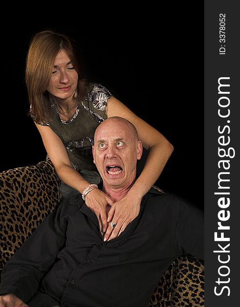 Sensual couple having fun on couch over black backdrop
