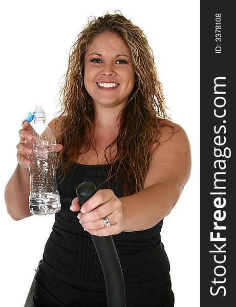 Beautiful 24 year old woman with bottle of water on exercise machine. Beautiful 24 year old woman with bottle of water on exercise machine.