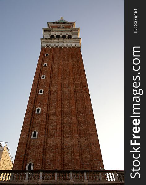 A wide angle shot of St. Mark's Square bell tower with red bricks