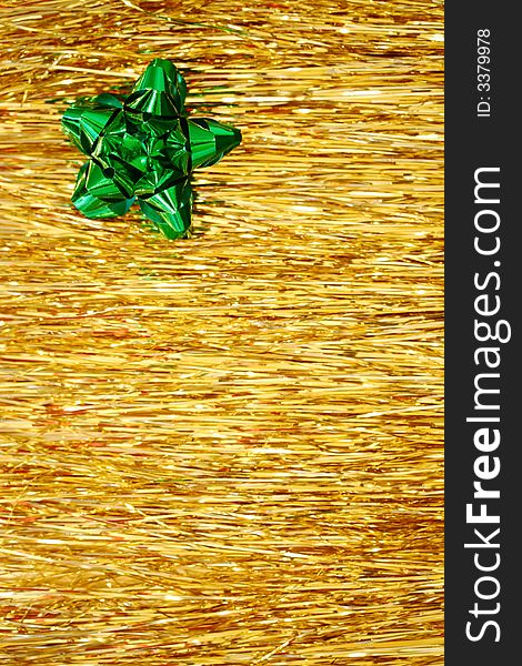A green Christmas ribbon on golden glittering strings - lametta. A green Christmas ribbon on golden glittering strings - lametta.