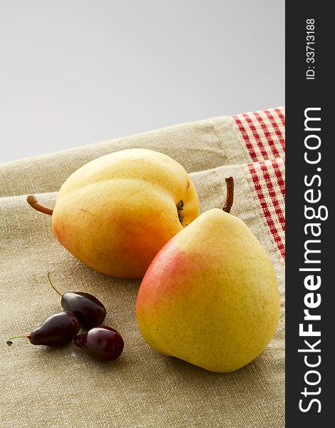 Ripe pears and dogwood berries on a linen napkin