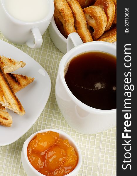 Coffee Break with Milk, Toasts, Apricot Jam and Puff Pastry closeup on Checkered background