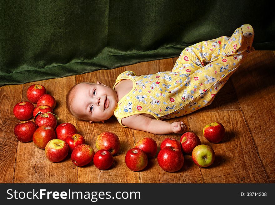 Redhead babe lying among ripe apple and smiling. Redhead babe lying among ripe apple and smiling