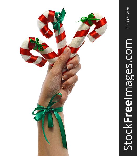 Hand with Christmas canes and green bow isolated. Hand with Christmas canes and green bow isolated