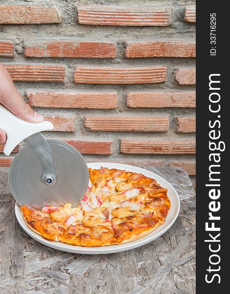 Hand cutting tasty home pizza. Hand cutting tasty home pizza