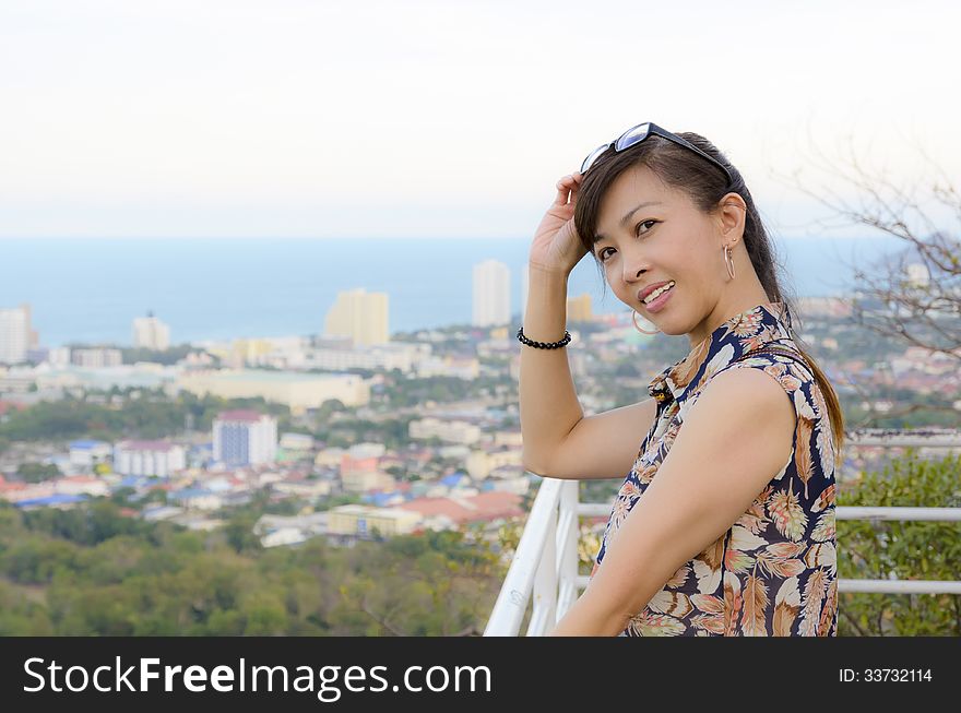 Woman poses on a high point overlooking the city.