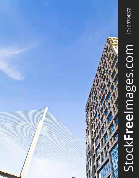 Big suspension bridge in beams of the coming sun against the blue sky