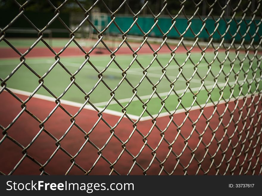 Tennis court in metal fence