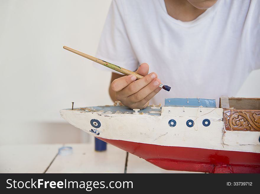 Boy Painting Old Wooden Ship