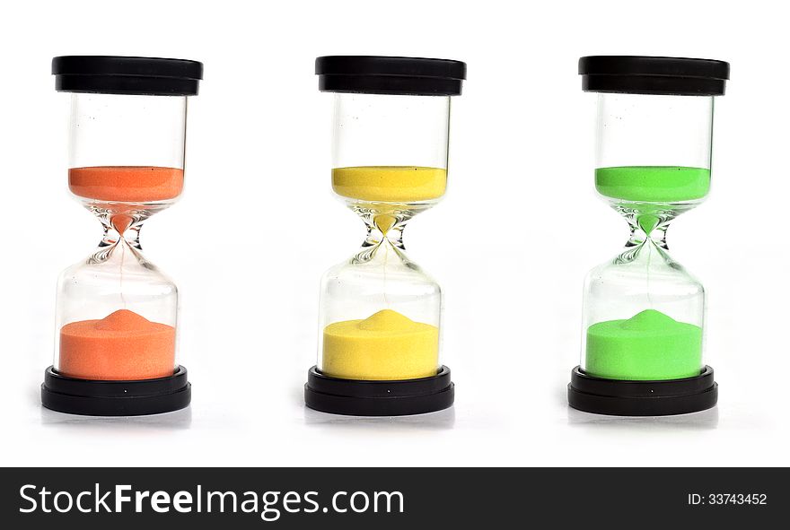 Three colored sand clocks of orange, yellow and green