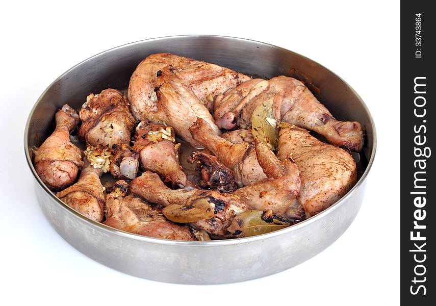 Baked chicken parts within a stainless round container. Baked chicken parts within a stainless round container