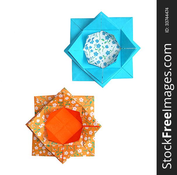 A pair of origami lotus flowers in turquoise and orange made from traditional paper with a floral pattern. A pair of origami lotus flowers in turquoise and orange made from traditional paper with a floral pattern.