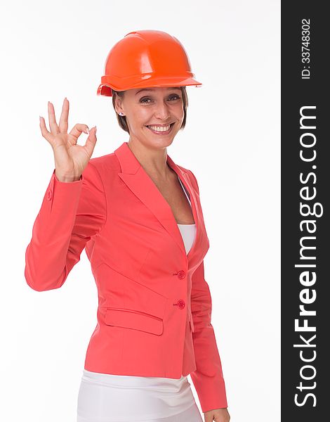Business woman in helmet and jacket show Okay isolated on white