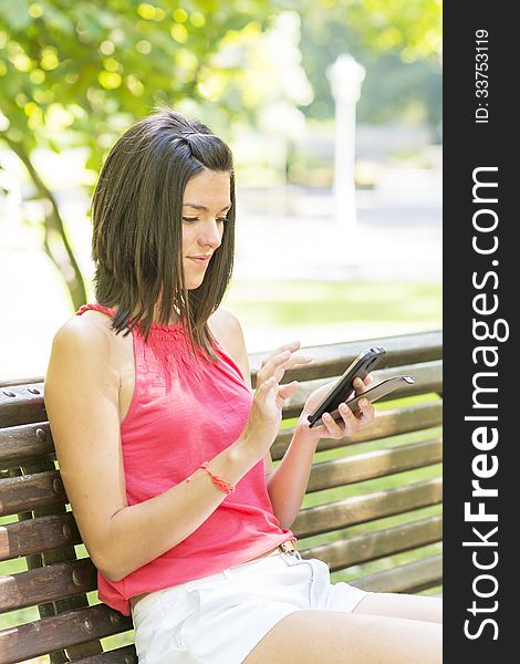 Beautiful girl using phone in the park. Beautiful girl using phone in the park.