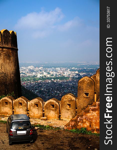 Car standing near fort wall looking down at city