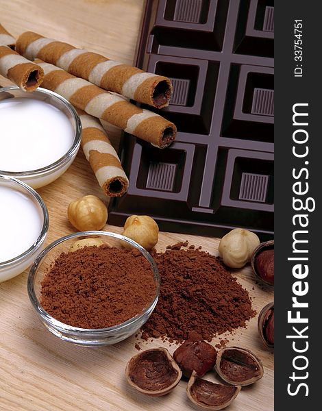 Dark chocolate with hazelnuts milk and cocoa sun wooden background. Dark chocolate with hazelnuts milk and cocoa sun wooden background