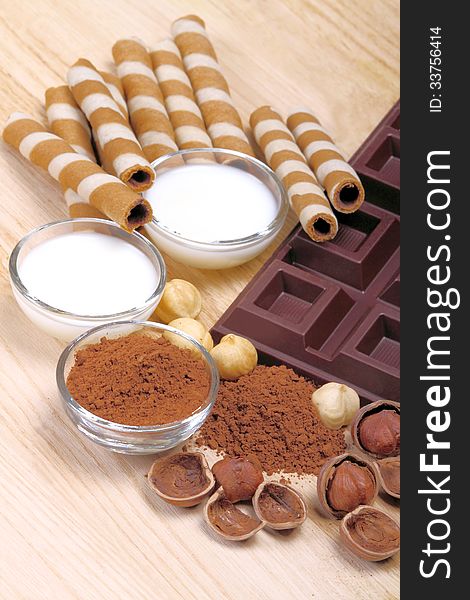 Dark chocolate with hazelnuts milk and cocoa sun wooden background. Dark chocolate with hazelnuts milk and cocoa sun wooden background