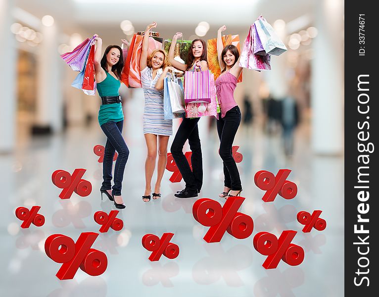 Happy women with shopping bags poses at store with three-dimensional text. Happy women with shopping bags poses at store with three-dimensional text