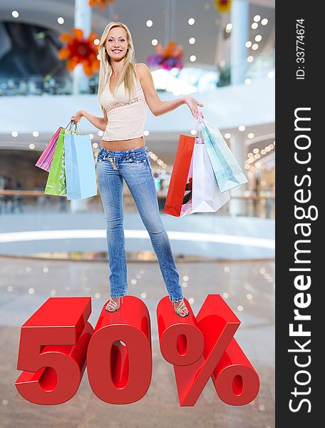 Woman with shopping bags poses at store with three-dimensional text