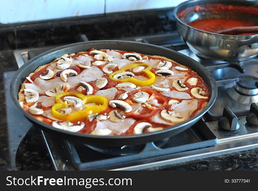 A pizza being prepared with all its ingredients to later be put in the stove. A pizza being prepared with all its ingredients to later be put in the stove