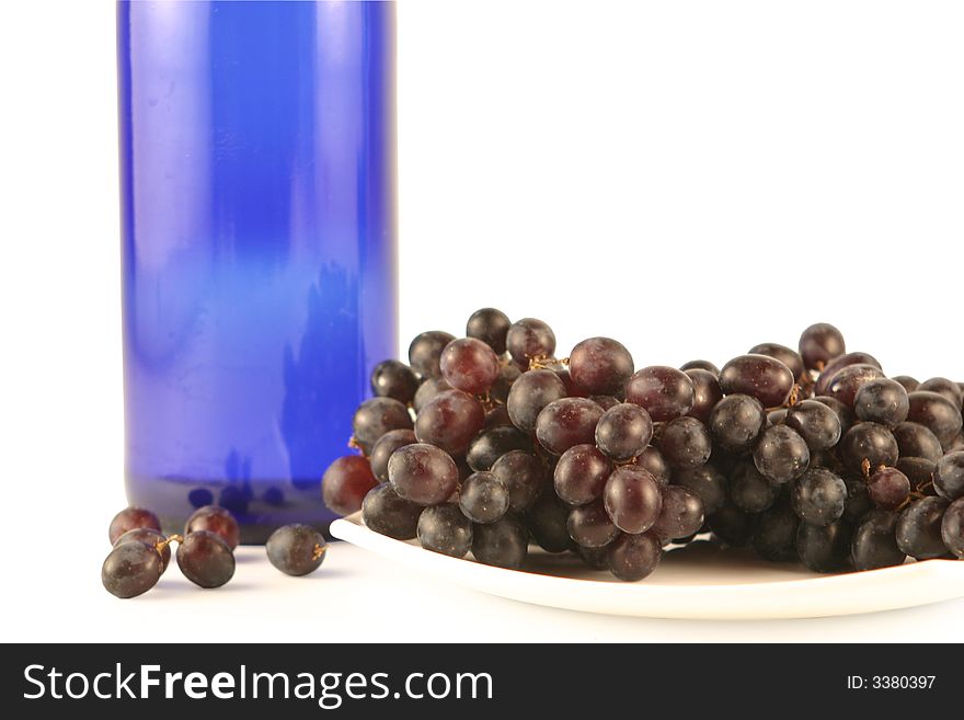 Bottle of wine and grapes  isolated on white
