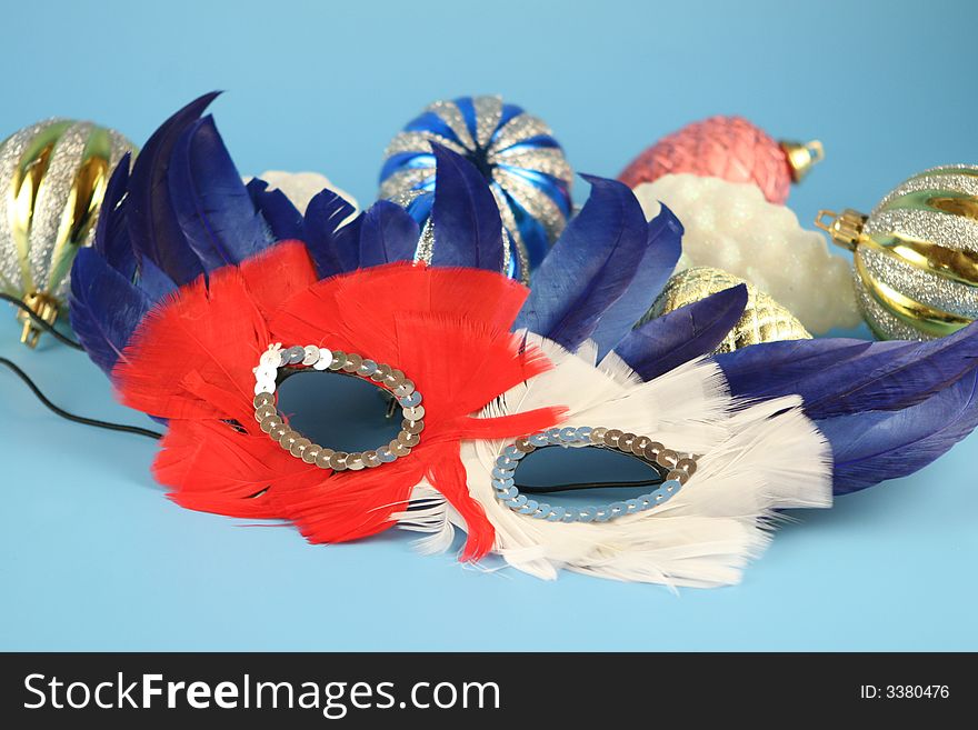 Christmas balls iand a carnival mask on a blue background. Christmas balls iand a carnival mask on a blue background.