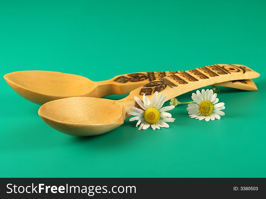 Wooden  spoons and  flowers on a green  background