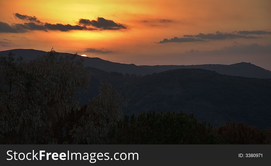 Sun setting behind mountain range. Sun setting behind mountain range