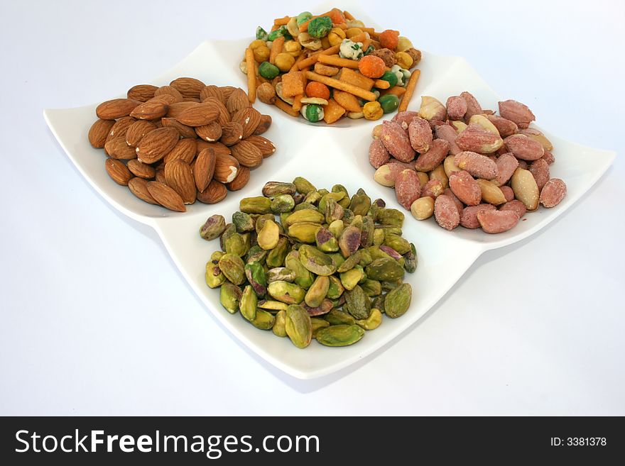 Different tasty nuts on the dish.Isolated. Different tasty nuts on the dish.Isolated.