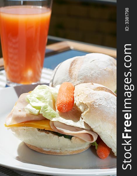 Ham and cheese sandwich on portuguese rolls served with juice