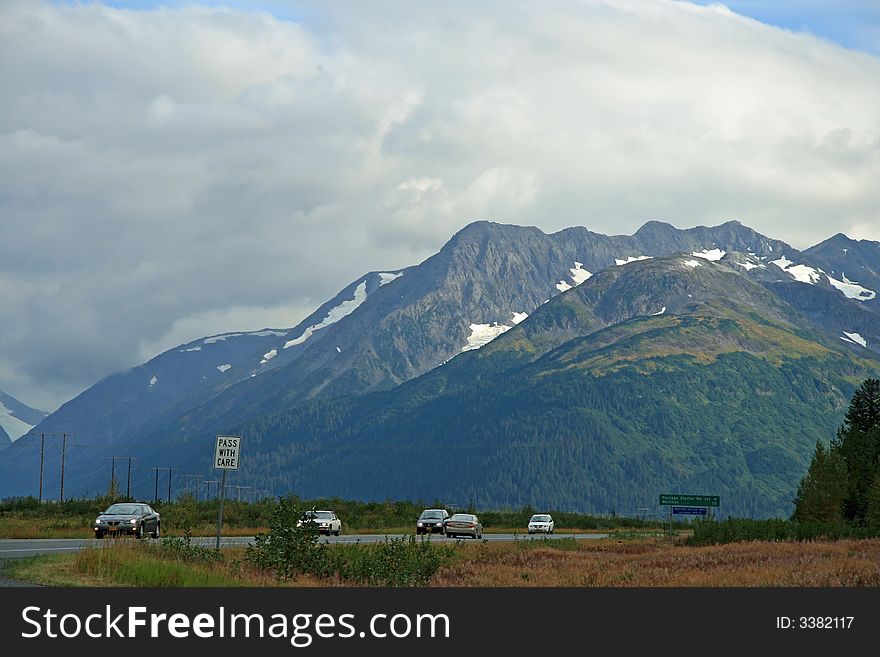 Alaska Highway with mountains in background.