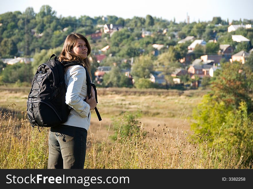 Young woman with backpack standing on the road