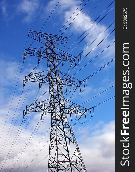 High tension lines, tower and clouds form patterns in the sky. High tension lines, tower and clouds form patterns in the sky