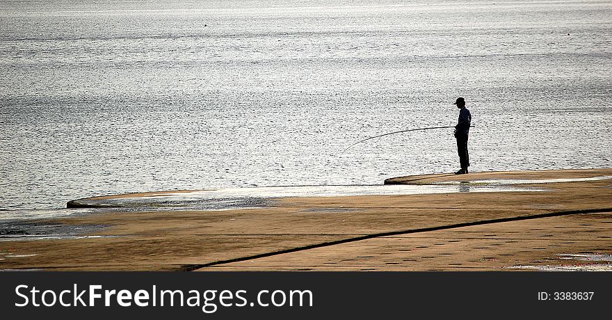 A man fishing on the beach. A man fishing on the beach.