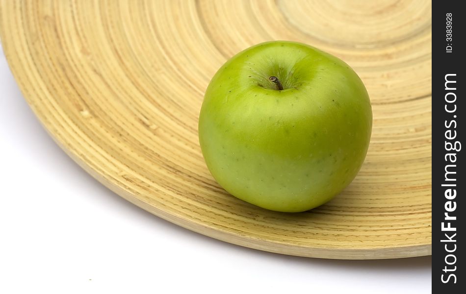 Green apple on a big bamboo plate