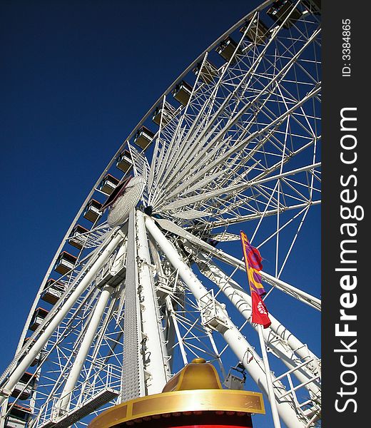 Vertical shot of a white Ferris wheel at a fair or carnival. Vertical shot of a white Ferris wheel at a fair or carnival